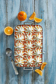 Homemade fresh vanilla-orange ice cream dessert with meringue pieces on a blue wooden background