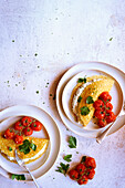 Gluten-free crêpes with herb ricotta and roasted vine tomatoes. Negative copy space.