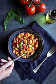 Ikarian style bean and fennel longevity stew, female hand with spoon.