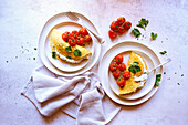 Glutenfreie Crepes mit Kräuter-Ricotta und gebratenen Rispentomaten. Horizontale Ausrichtung.