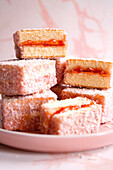 Australischer rosa Lamington Kleiner quadratischer Kuchen mit Erdbeermarmelade und Kokosnussüberzug.