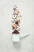 Coffee turk and flying coffee beans and macarons on concrete background flat lay