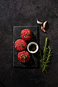 Beef Burger Patties on a Black Slate