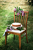 A yellow cake on a rustic chair in a garden during summer