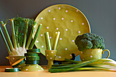 Green vegetables with green polka dot tableware, color blocking aesthetic. Green foods contain phytonutrients that have a beneficial effect on the immune system and prevent cellular damage.