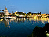 Blick bei Sonnenuntergang auf den Fluss Guadalquivir mit dem Torre del Oro (Goldener Turm), einem zwölfeckigen militärischen Wachturm, der vom Almohadenkalifat errichtet wurde, Sevilla, Andalusien, Spanien, Europa