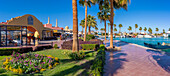 Blick auf das Café und die Uferpromenade im Yachthafen von Hurghada mit der Al-Mina-Moschee im Hintergrund, Hurghada, Rotes Meer Gouvernement, Ägypten, Nordafrika, Afrika