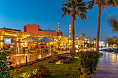 Blick auf Café und Restaurant im Yachthafen von Hurghada und die Al-Mina-Moschee im Hintergrund in der Abenddämmerung, Hurghada, Verwaltungsbezirk Rotes Meer, Ägypten, Nordafrika, Afrika