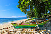 Auslegerkanus am Strand von Pulisan mit dem Berg Tangkoko und dem dahinter liegenden Nationalpark, Pulisan, Minahasa-Hochland, Nordsulawesi, Indonesien, Südostasien, Asien