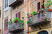 Traditionelle Architektur von Häusern mit Eisenbalkonen und Blumen, hölzernen Fensterläden und leicht verfallenen Fassaden, Palermo, Sizilien, Italien, Mittelmeerraum, Europa