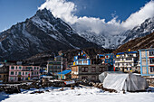 Bunte Häuser von Kyanjin Gompa Town mit dem Gipfel des Langtang Lirung über dem Dorf, Lang Tang Valley Trek, Himalaya, Nepal, Asien