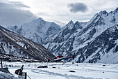 Hubschrauberlandung auf einem Schneefeld vor einer hochgelegenen Berglandschaft mit dem Gangchempo-Gipfel, Langtang Valley Trek, Himalaya, Nepal, Asien