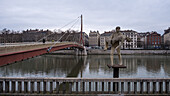 Stadtbild der Stadt Lyon in Frankreich vom Ufer der Saone aus mit der Skulptur "The Weight of Oneself" im Vordergrund vor dem Gerichtsgebäude, Lyon, Auvergne Rhone Alpes, Frankreich, Europa