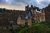 Eltz mittelalterliche historische Burg in einer Herbstlandschaft mit Bäumen bei Sonnenaufgang, Wierschem, Rheinland-Pfalz, Deutschland, Europa