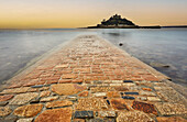 St. Michael's Mount im frühen Morgenlicht und bei abnehmender Flut, wobei der Damm zwischen der Insel und dem Festland bei Marazion noch weitgehend unter Wasser steht, Marazion, nahe Penzance, Cornwall, England, Vereinigtes Königreich, Europa