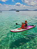 Kids on a SUP in the turquoise waters of the Formentor Peninsula, Mallorca, Balearic islands, Spain, Mediterranean, Europe