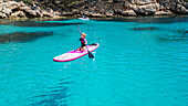 Luftaufnahme eines jungen Mädchens beim Paddeln auf einem SUP auf der Halbinsel Formentor, Mallorca, Balearen, Spanien, Mittelmeer, Europa