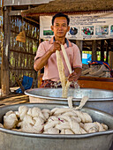 Ein Mann reinigt Wolle zum Färben in dem kleinen Dorf Angkor Ban, Provinz Battambang, Kambodscha, Indochina, Südostasien, Asien