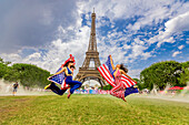 Patriotische amerikanische Frau springt und jubelt für das Team USA und die Olympischen Spiele Paris 2024 vor dem Eiffelturm, Paris, Frankreich, Europa