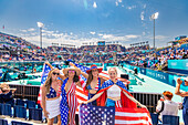 Patriotische amerikanische Frau springt und jubelt für das Team USA und die Olympischen Spiele Paris 2024 vor dem Eiffelturm, Paris, Frankreich, Europa