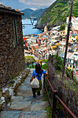 Ein einsamer Tourist nähert sich Vernazza, einer Küstenstadt in der Provinz La Spezia, Region Cinque Terre, UNESCO-Weltkulturerbe, Ligurien, Italien, Europa