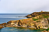 Portu su Gaurru wild beach in the coast of Sardinia with historic tower on the top of the cliff, Sardinia, Italy, Mediterranean, Europe