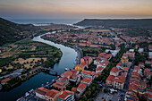 Bosa bunte Stadtgebäude, Drohnen-Luftaufnahme mit Temo-Fluss und Mittelmeer bei Sonnenuntergang, Bosa, Sardinien, Italien, Mittelmeer, Europa