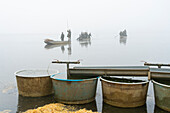 Equipment ready for fish harvest on Rozmberk Pond with fishermen on boats in background, UNESCO Biosphere, Trebon, Jindrichuv Hradec District, South Bohemian Region, Czech Republic (Czechia), Europe