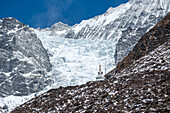 Nahaufnahme einer Stupa (Chorten) an einem Berghang vor Gletschern, Kyanjin Gompa, Langtang-Tal-Trek, Himalaya, Nepal, Asien