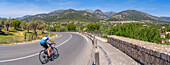 View of cyclist near hilltop town of Caimari and vineyard, Majorca, Balearic Islands, Spain, Mediterranean, Europe