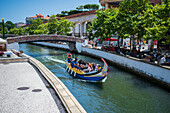 Bootsfahrt durch die Kanäle in einem farbenfrohen, traditionellen Moliceiro-Boot, Aveiro, Portugal