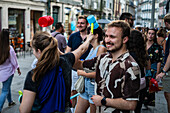 Begrüßung von Menschen mit welkem Lauch und Plastikhämmern während des Johannisfestes von Porto (Festa de Sao Joao do Porto ) in der Nacht zum 23. Juni (Johannisnacht) in der Stadt Porto, Portugal