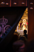 Ein Blick hinter die Vorhänge der Kapelle Capilla de los Marineros in Sevilla, Spanien. Die Gläubigen betreten die Kapelle, um die Esperanza de Triana zu verehren.