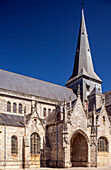 Exterior view of the Collegiale Saint Aubin church in Guerande, France, showcasing its Gothic architecture and ancient stone construction.