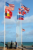 Flaggen der alliierten Nationen wehen am Goldstrand, Arromanches, Normandie, Frankreich. Eine historische Stätte zum Gedenken an die D-Day-Landungen im Zweiten Weltkrieg.