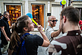 Begrüßung von Menschen mit welkem Lauch und Plastikhämmern während des Johannisfestes von Porto (Festa de Sao Joao do Porto ) in der Nacht des 23. Juni (Johannisnacht) in der Stadt Porto, Portugal