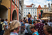 Künstlerin spielt Geige, während sie auf Stelzen bei der Puppenparade vom Marienplatz zum Altstädter Ring läuft, während des Prager Straßentheaterfestivals Behind the Door, Prag, Tschechische Republik