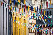 Festive and colorful street decorations with flags hanging in the historic streets of Vannes, Brittany, France.