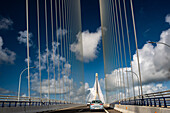 Photo of the Constitution of 1812 Bridge, also known as La Pepa Bridge, located in Cadiz, Andalusia, Spain with cars driving under a blue sky.