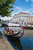 Bootsfahrt durch Kanäle in einem farbenfrohen, traditionellen Moliceiro-Boot, Aveiro, Portugal