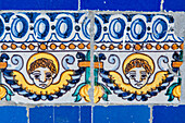 Cherubs depicted on ornate glazed ceramic tiles at the Fine Arts Museum in Seville, Spain, showcasing intricate artwork.