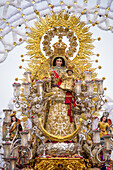 La Virgen del Rosario, an 18th-century statue, during a procession in Carrión de los Céspedes, Sevilla, Spain. The image depicts rich religious tradition and cultural heritage.