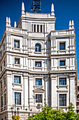 Nahaufnahme des Edificio De Correos, eines ikonischen Gebäudes in Granada, Andalusien, Spanien, das klassische Architektur vor einem klaren blauen Himmel zeigt.