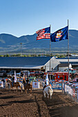 Junge Cowboys und Cowgirls reiten an den Flaggen der USA und des Bundesstaates Utah vorbei, während des großen Einzugs bei einem Rodeo in einer ländlichen Kleinstadt in Utah.