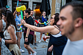 Begrüßung von Menschen mit welkem Lauch und Plastikhämmern während des Johannisfestes von Porto (Festa de Sao Joao do Porto ) in der Nacht zum 23. Juni (Johannisnacht) in der Stadt Porto, Portugal