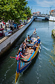 Bootsfahrt durch Kanäle in einem farbenfrohen, traditionellen Moliceiro-Boot, Aveiro, Portugal