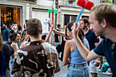 Begrüßung von Menschen mit welkem Lauch und Plastikhämmern während des Johannisfestes von Porto (Festa de Sao Joao do Porto ) in der Nacht zum 23. Juni (Johannisnacht) in der Stadt Porto, Portugal