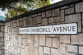 Nahaufnahme eines Straßenschilds an der Winston Churchill Avenue in Gibraltar, UK. Hintergrund ist eine Steinmauer.