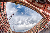 Fischaugenansicht der Plaza de la Corredera in Córdoba, Andalusien, die die architektonische Schönheit des Platzes unter einem bewölkten Himmel zeigt.