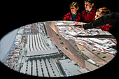 Visitors examine an image of downtown Sevilla projected inside a camera obscura exhibit, appreciating the detailed cityscape.